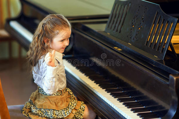 可爱的小女孩在音乐学校弹大钢琴