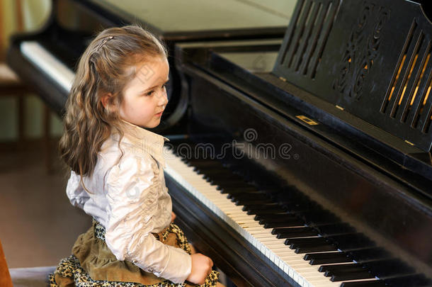 可爱的小女孩在<strong>音乐学校</strong>弹大钢琴
