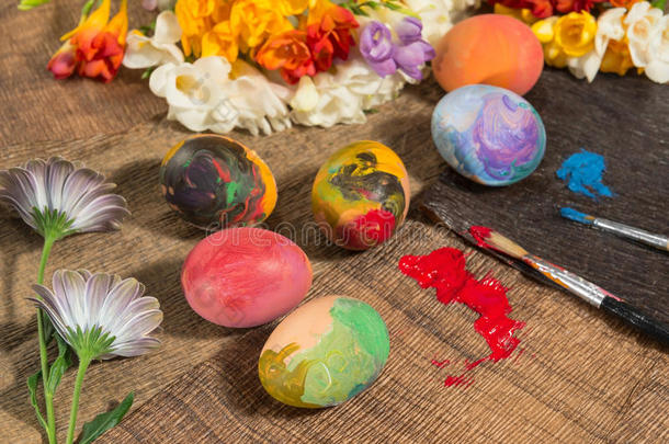 复活节五颜六色的鸡蛋，春天的花和两个画家的刷子。