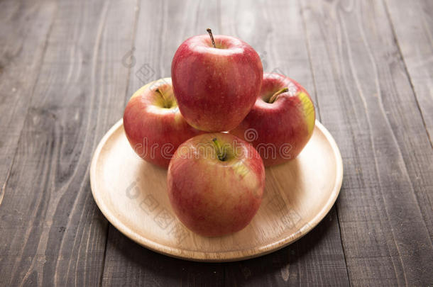 新鲜成熟的红色苹果在盘木背景上
