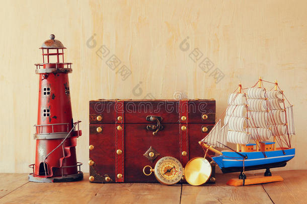 古董指南针，老式灯塔，木船和木制桌子上的旧箱子