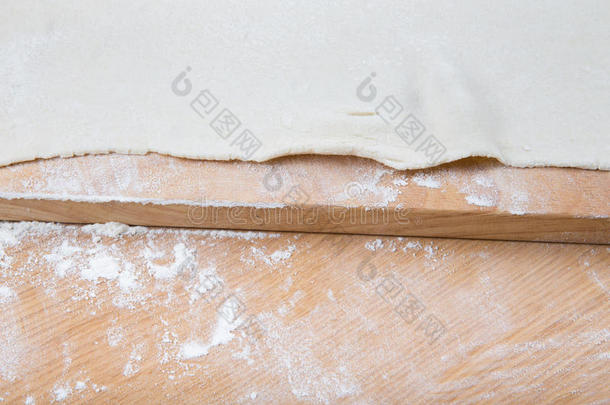 面团放在一张轻木桌上，上面有面粉