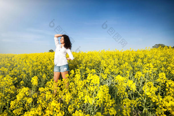 美丽的快乐女人在菜籽油田