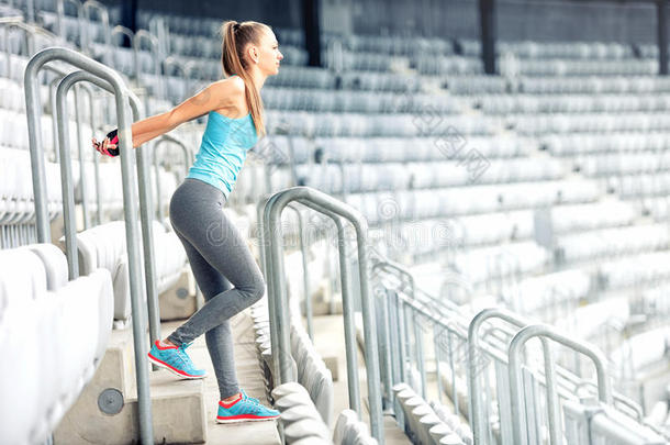 健身女孩做健身运动，在体育场楼梯上<strong>锻炼</strong>。 慢跑者<strong>晨练</strong>，健康的生活方式概念
