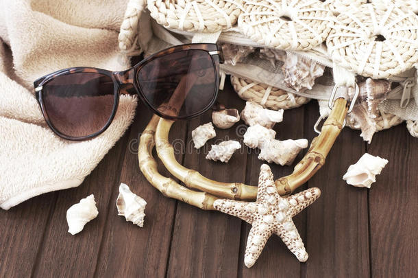 沙滩包，毛巾，太阳镜和帽子在木制背景上
