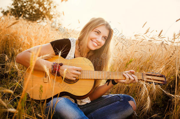 女孩在麦田里弹吉他