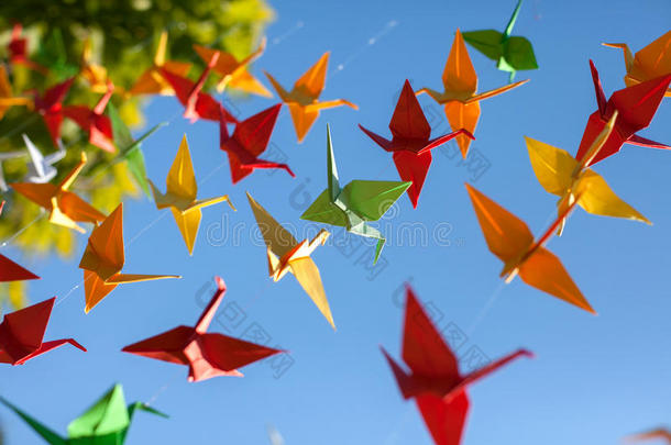 五颜六色的折纸鸟在飞翔。 天空背景。