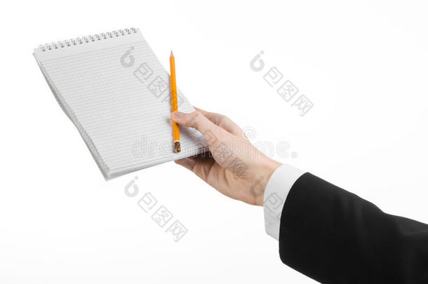 商业和记者的话题：穿着黑色西装的记者手拿着一本白色背景上有铅笔的笔记本