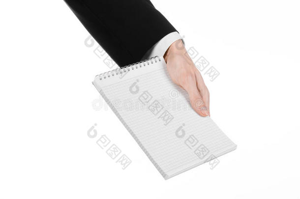 商业和记者的话题：穿着黑色西装的记者手拿着一本白色背景上有铅笔的笔记本