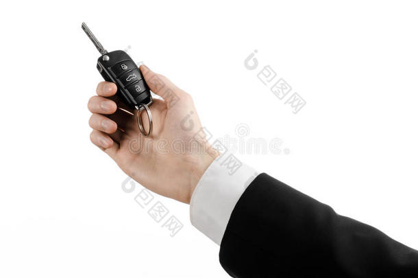 业务主题：汽车销售员穿着黑色西装，拿着一把汽车钥匙，在白色背景上隔离
