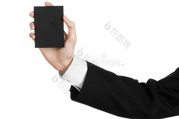 商业和广告主题：穿着黑色西装的男人手里拿着一张黑色的空白卡，在工作室的白色背景上隔离