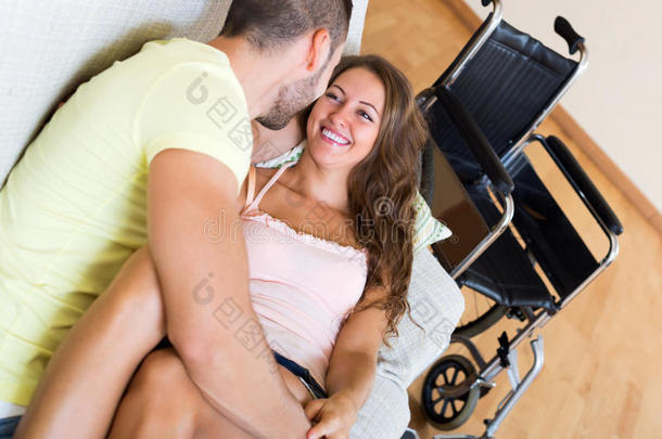 一对夫妇坐在轮椅旁的沙发上