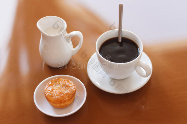 一杯<strong>咖啡</strong>，<strong>奶</strong>油罐和松饼在反光桌子上