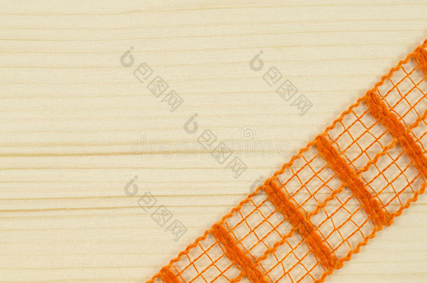 木制背景上橙色丝带的框架