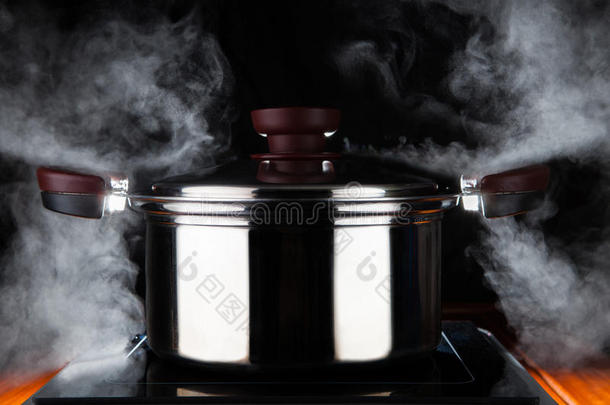 在电磁炉上用无节钢锅的热流功率烹饪食物，用于厨房和膳食准备主题