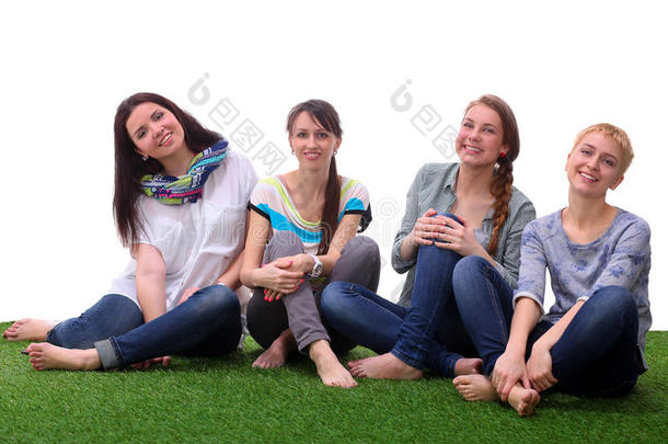 四个年轻的女人<strong>坐在</strong>绿色的草<strong>地上</strong>