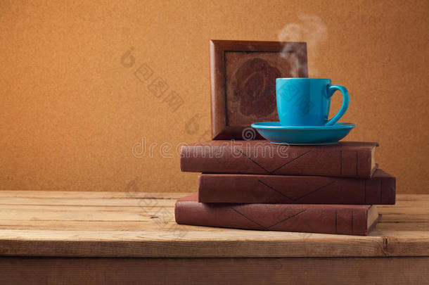 复古背景下木制老式桌子上的咖啡杯和书