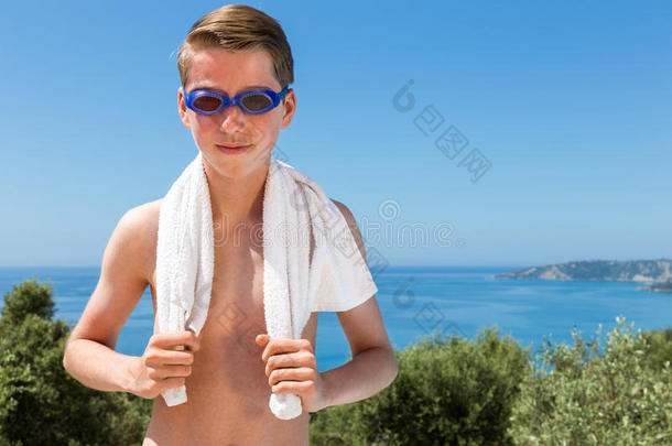 海边带毛巾和<strong>泳镜</strong>的男孩