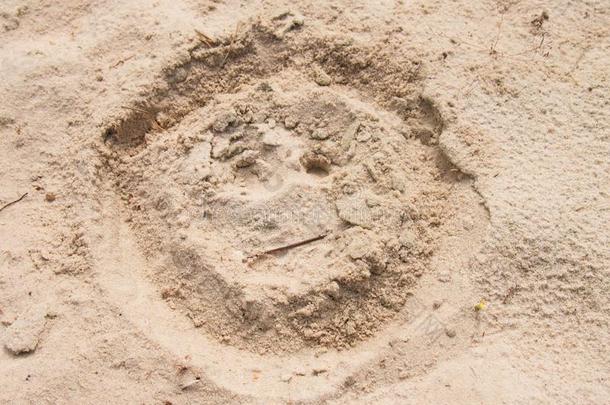 在夏天的海滩沙滩上画着笑脸。 用单调的盐沙画头。