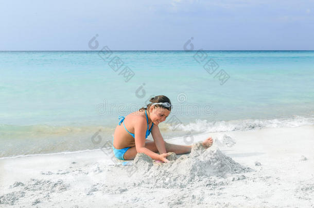 小女孩在海边的白沙华丽的海滩上玩耍