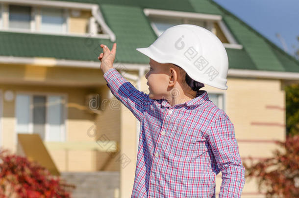 戴着安全帽的男孩展示了成品房子