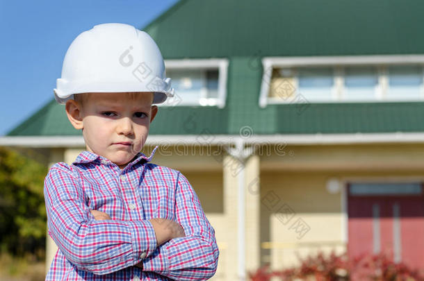 戴着安全帽的男孩展示了成品房子
