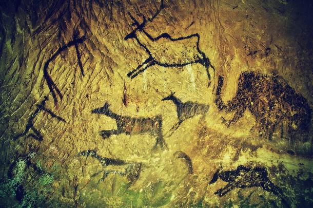 抽象儿童艺术在砂岩洞穴。 砂岩墙上人类狩猎的黑色碳漆，史前图片的副本。