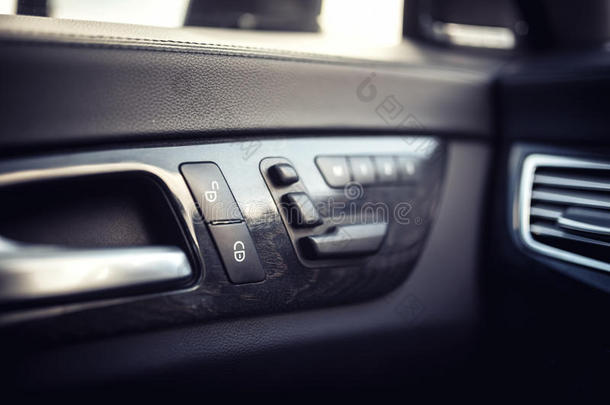 汽车皮革内部细节的门把手与窗户控制，座位调整。 汽车的现代门窗控制