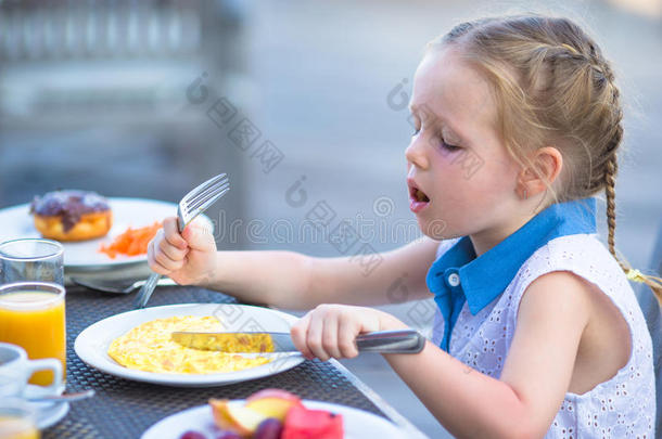 可爱的小女孩在户外吃早餐