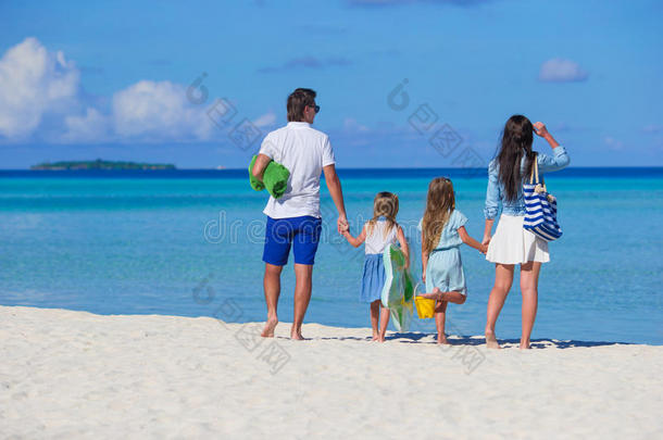 年轻的一家四口在海滩度假