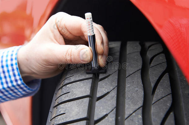 用量规检查汽车轮胎胎面的人员特写