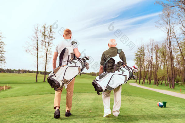 球场上步行高尔夫球员的后视图