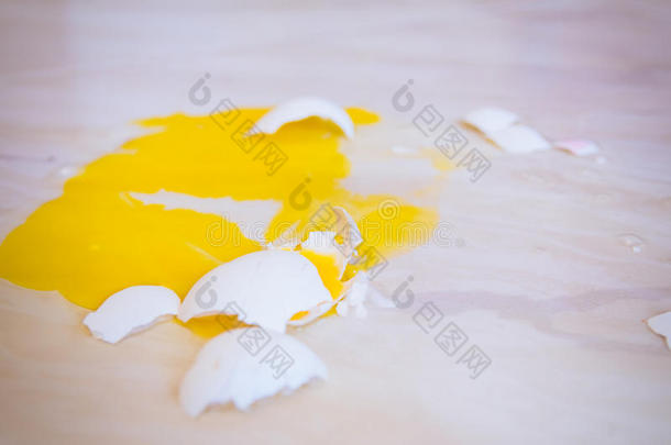 掉在地板上的碎蛋到处都是黄色的蛋黄