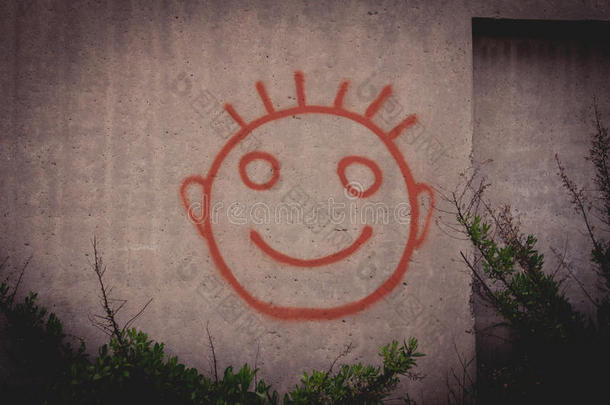 在混凝土墙上涂鸦红色快乐笑脸