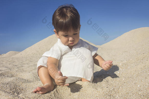 穿着阿拉伯连衣裙的男孩在沙丘中玩耍
