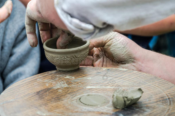 陶工的手在集市上的街上做一个陶罐