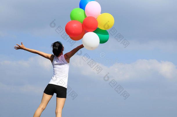 亚洲女人用<strong>彩色</strong>气球在山顶<strong>岩石</strong>上张开双臂