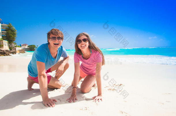 <strong>亲密</strong>的年轻白种人夫妇戴着太阳镜在海滩上微笑