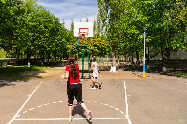 一对夫妇在户外球场打篮球
