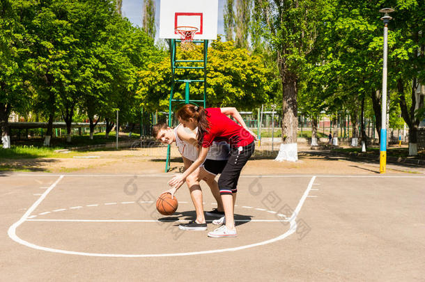 一对夫妇在户外球场打篮球