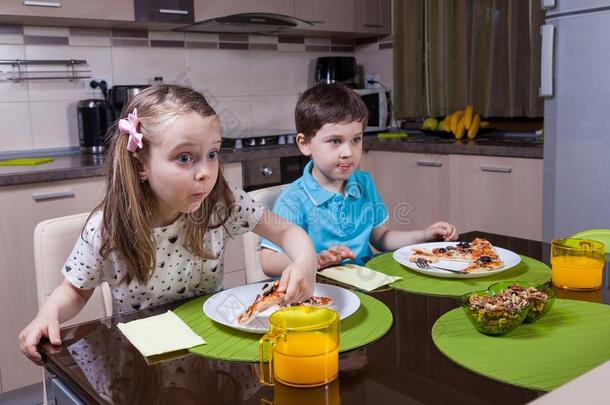 孩子们在吃饭时被电视节目迷住了