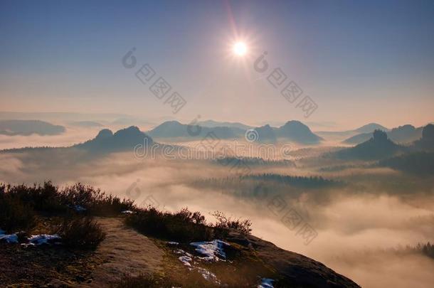 梦幻般的朦胧景观。 雄伟的山划破了灯光的薄雾。 深谷里充满了五颜六色的雾，岩石在粘着