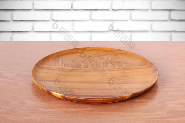 白色砖墙背景上桌子上的空圆木托盘