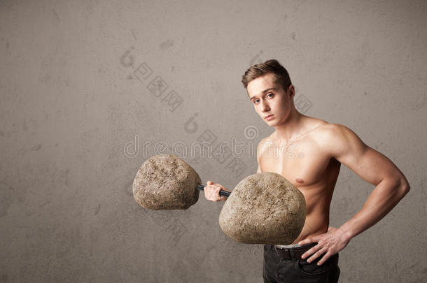 肌肉发达的男子举起大石头重物