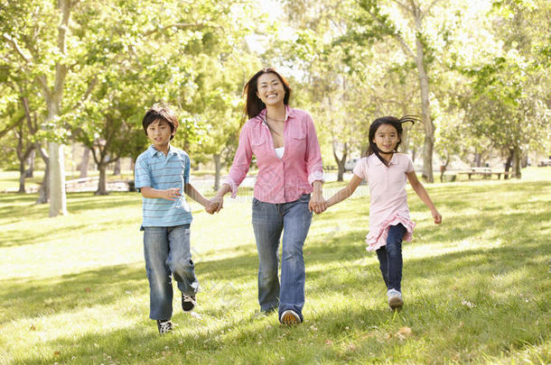 亚洲的母亲和孩子在公园里手拉手地奔跑