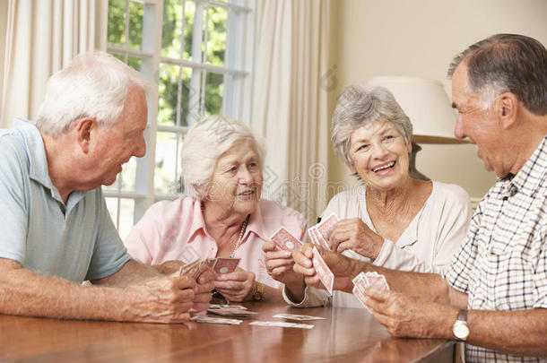 一群在家里享受纸牌游戏的老年夫妇