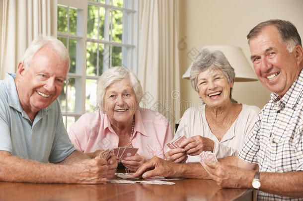 一群在家里享受纸牌游戏的老年夫妇