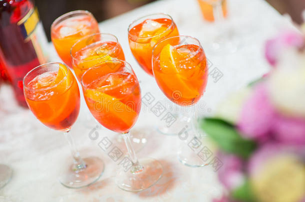 在喜庆的桌子上放着橙色鸡尾酒的眼镜。