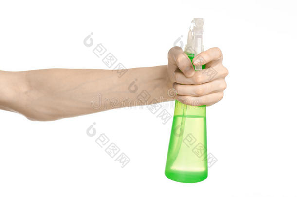 清洁房子和清洁主题：男人的手拿着一个绿色的喷雾瓶，用于清洁白色背景上的隔离物