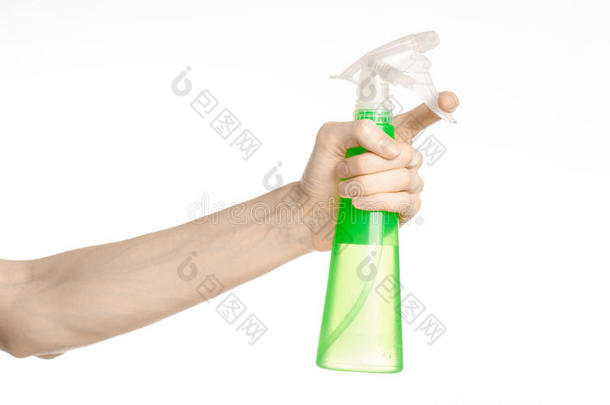 清洁房子和清洁主题：男人的手拿着一个绿色的喷雾瓶，用于清洁白色背景上的隔离物